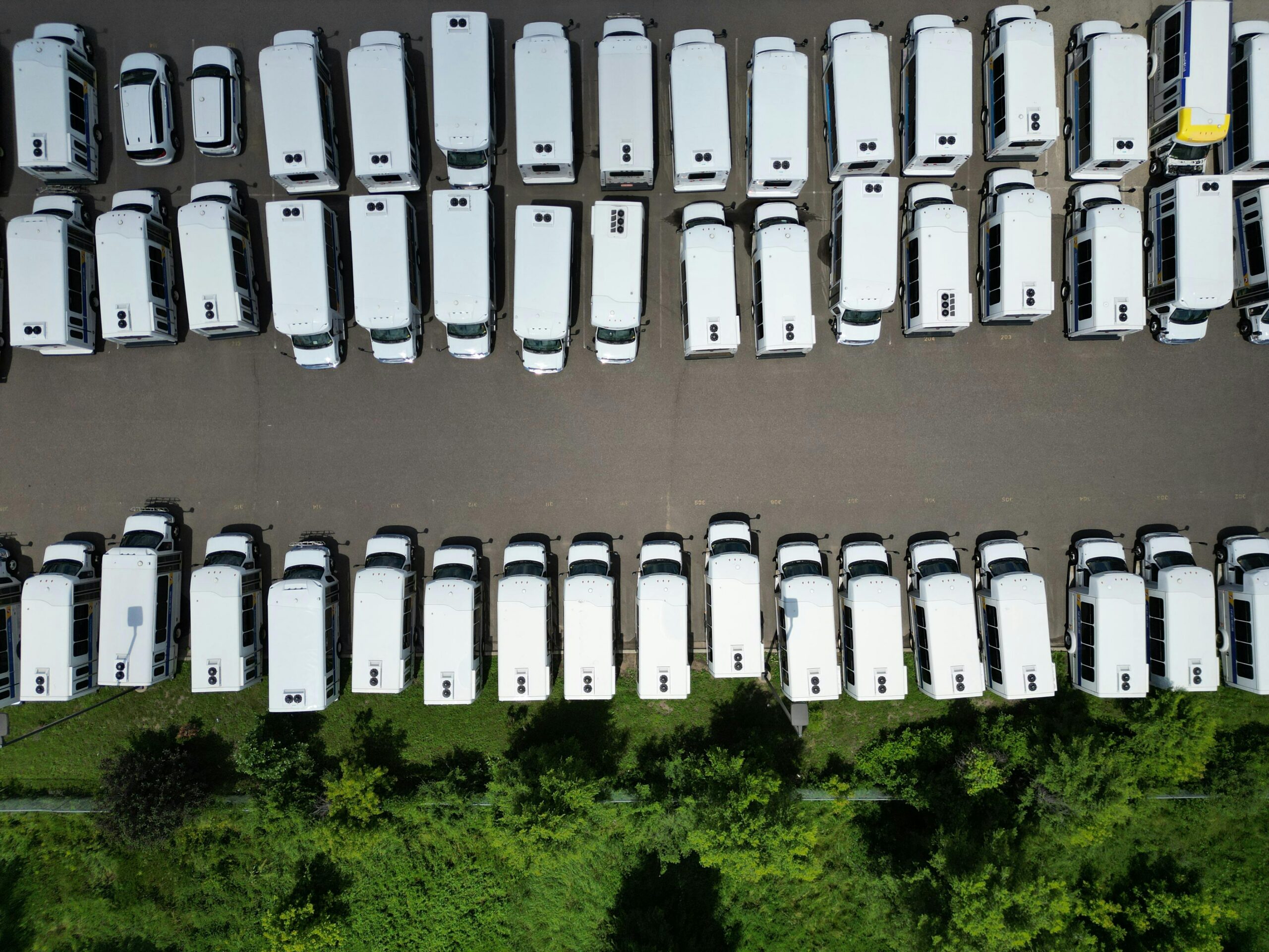 Aerial view of commercial electric fleet vehicles parked in rows for clean fleet mandate planning